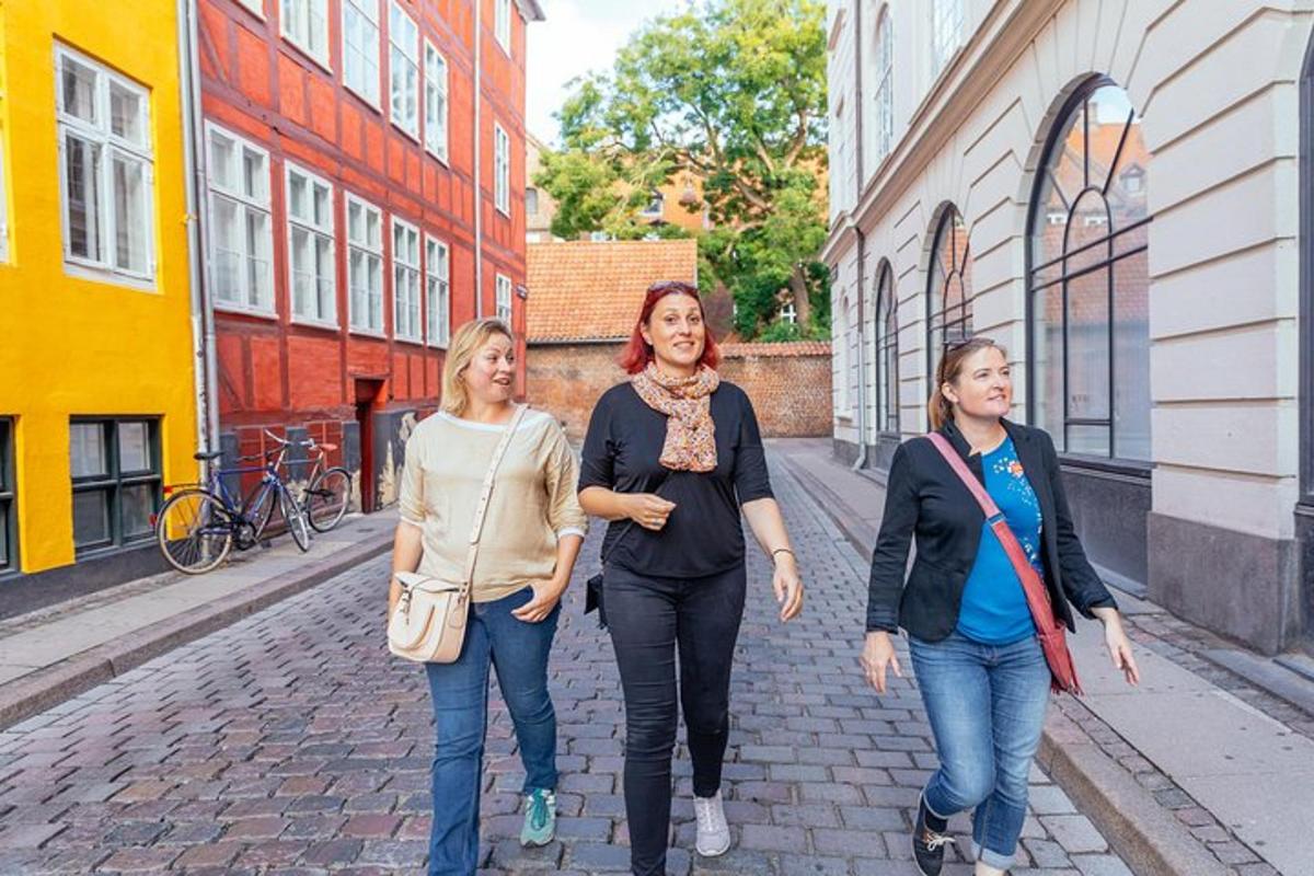 três mulheres caminhando por uma rua de tijolos