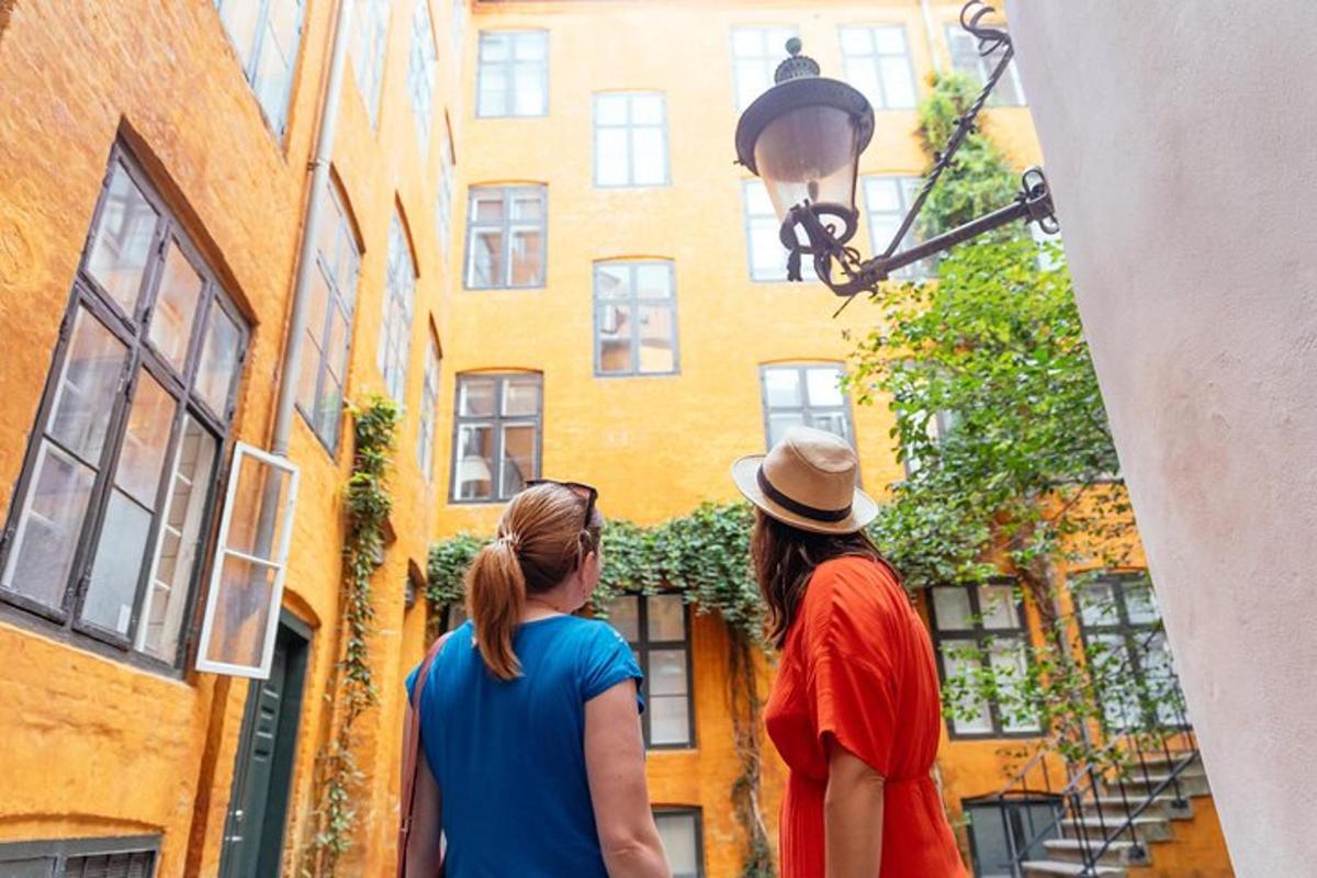 Dos mujeres mirando un edificio en un callejón.