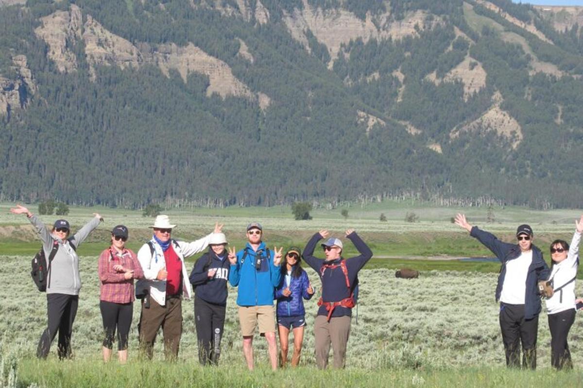 a group of people standing in a field with their hands up