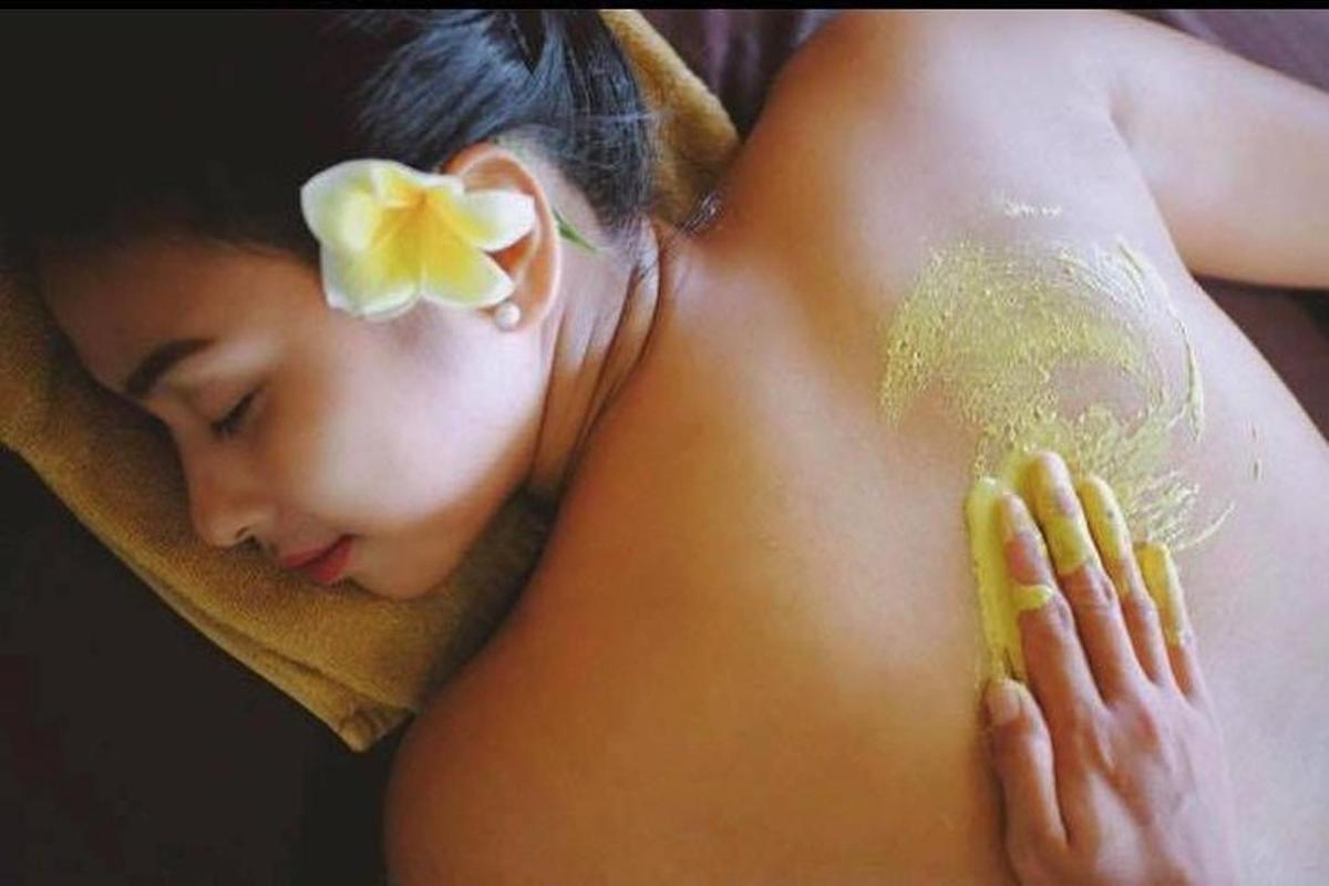 a woman with a towel on her back with a flower on her head