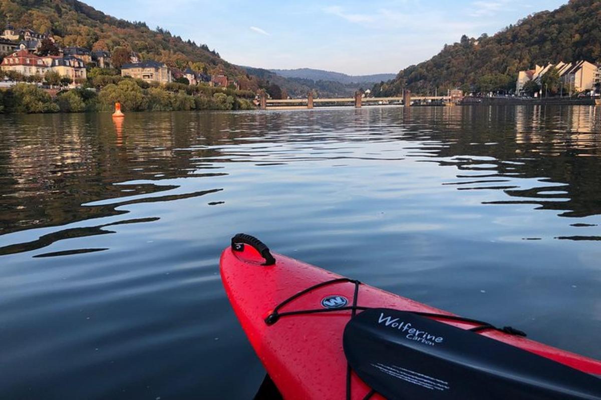 a red kayak sitting in the water in a lake