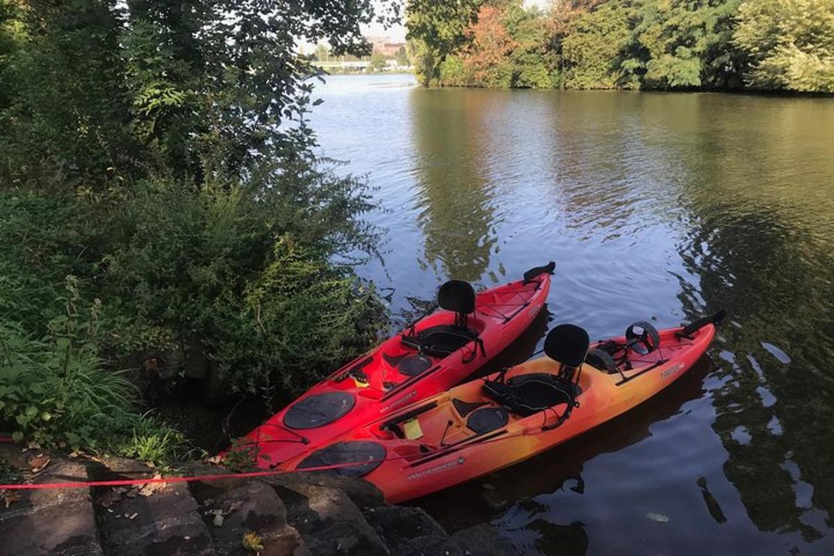 a red kayak sitting on the side of a river