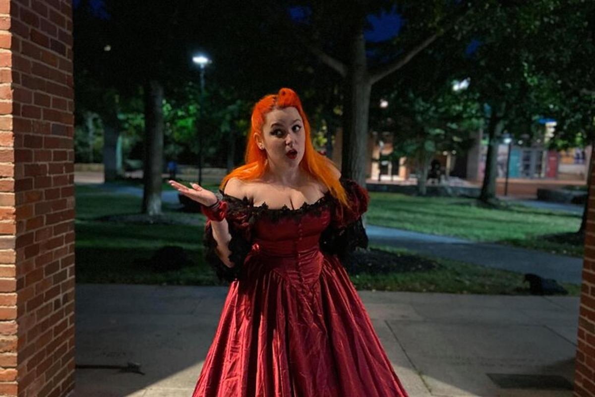 Una mujer con un vestido rojo parada en una acera