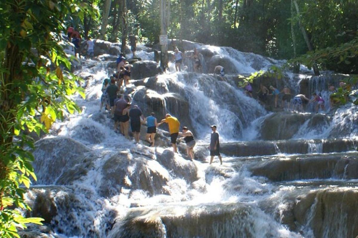 un grup de persones dempeus sobre les roques d'una cascada