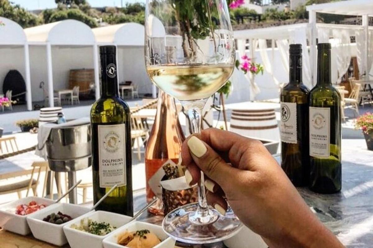 eine Person, die ein Glas Weißwein hält