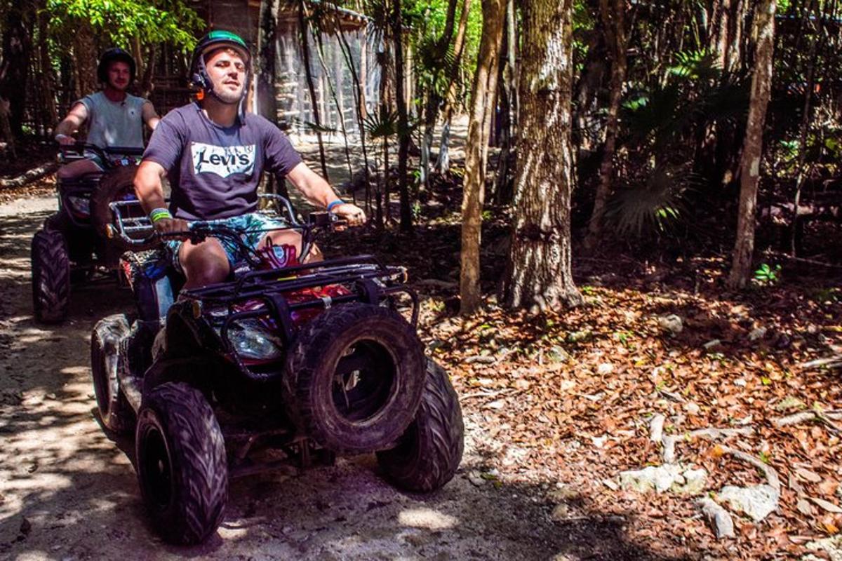 a man sitting on a four wheeler in the woods
