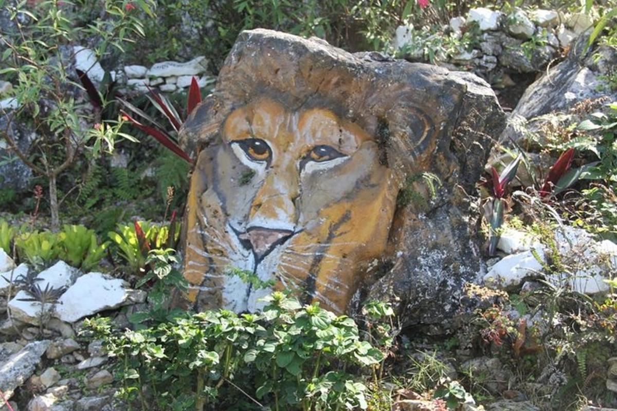 una estatua de un león pintada en un tocón de árbol