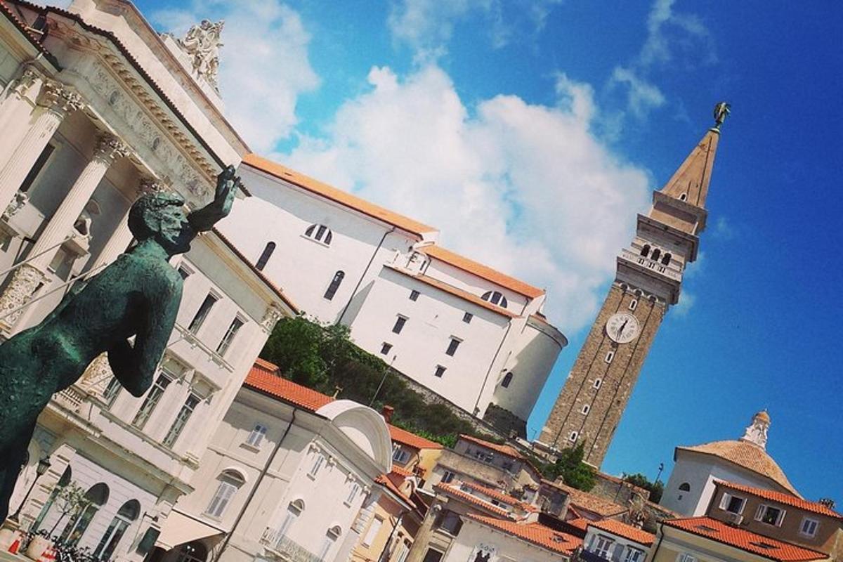 a building with a statue in front of a clock tower