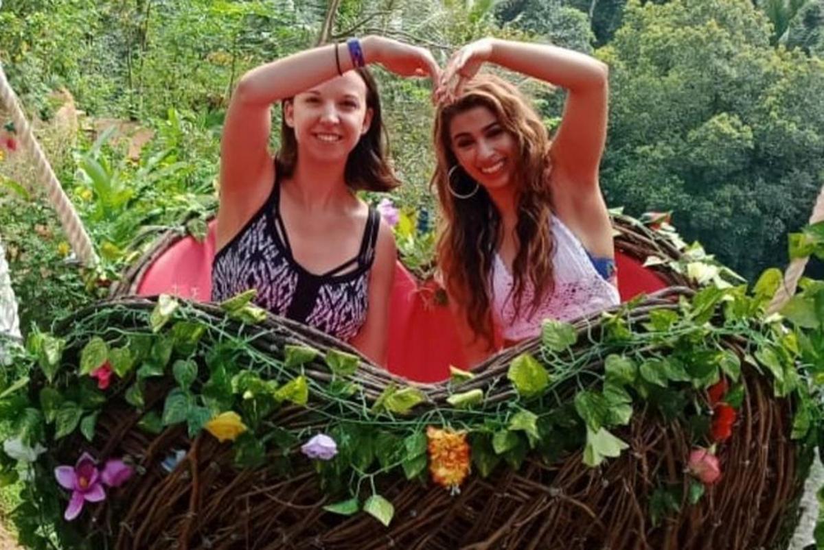 dua wanita duduk di dalam kereta sorong yang dipenuhi dengan tumbuhan