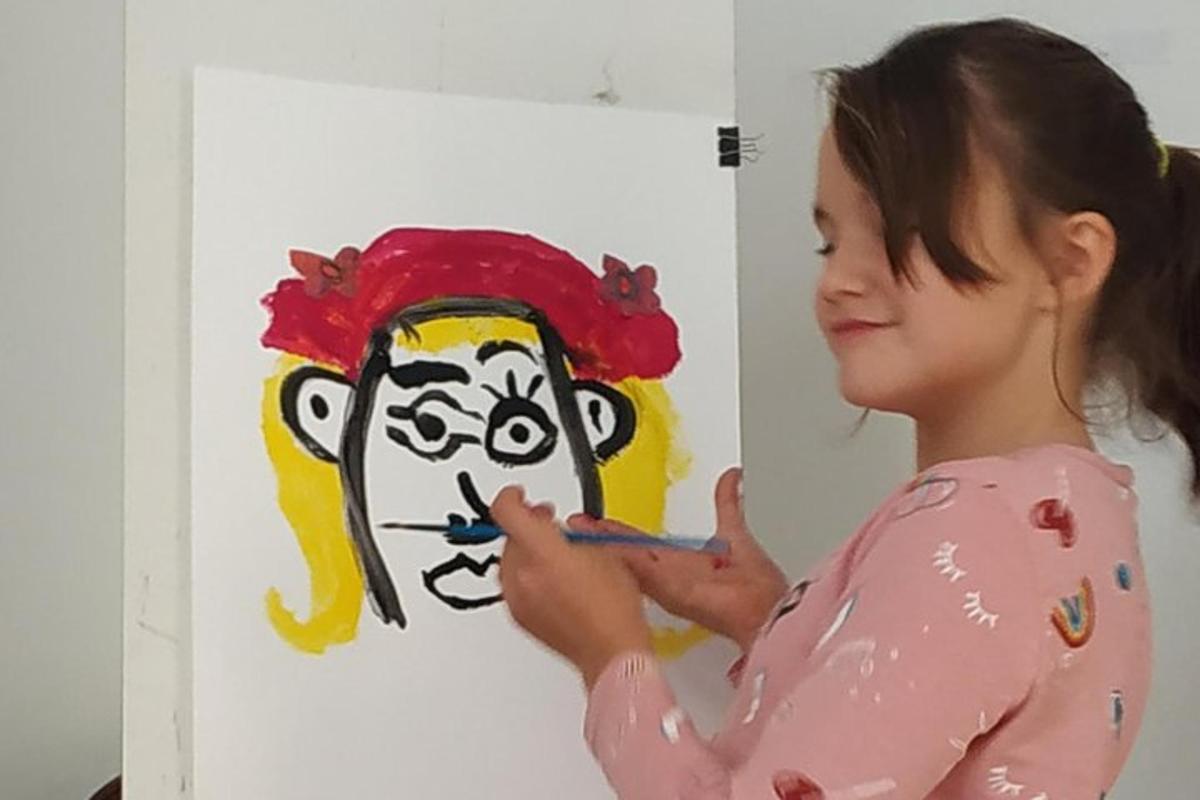 a young girl painting a picture of a monkey