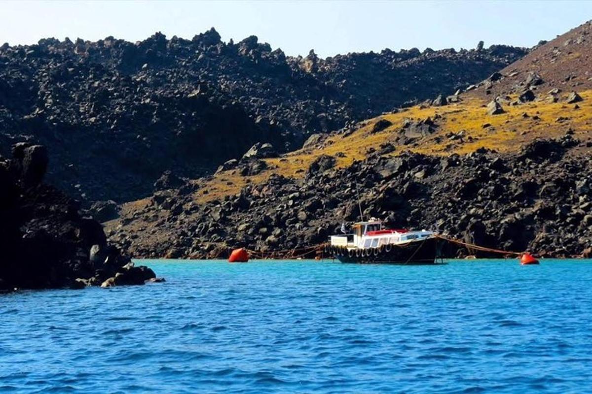 un barco en el agua al lado de una montaña