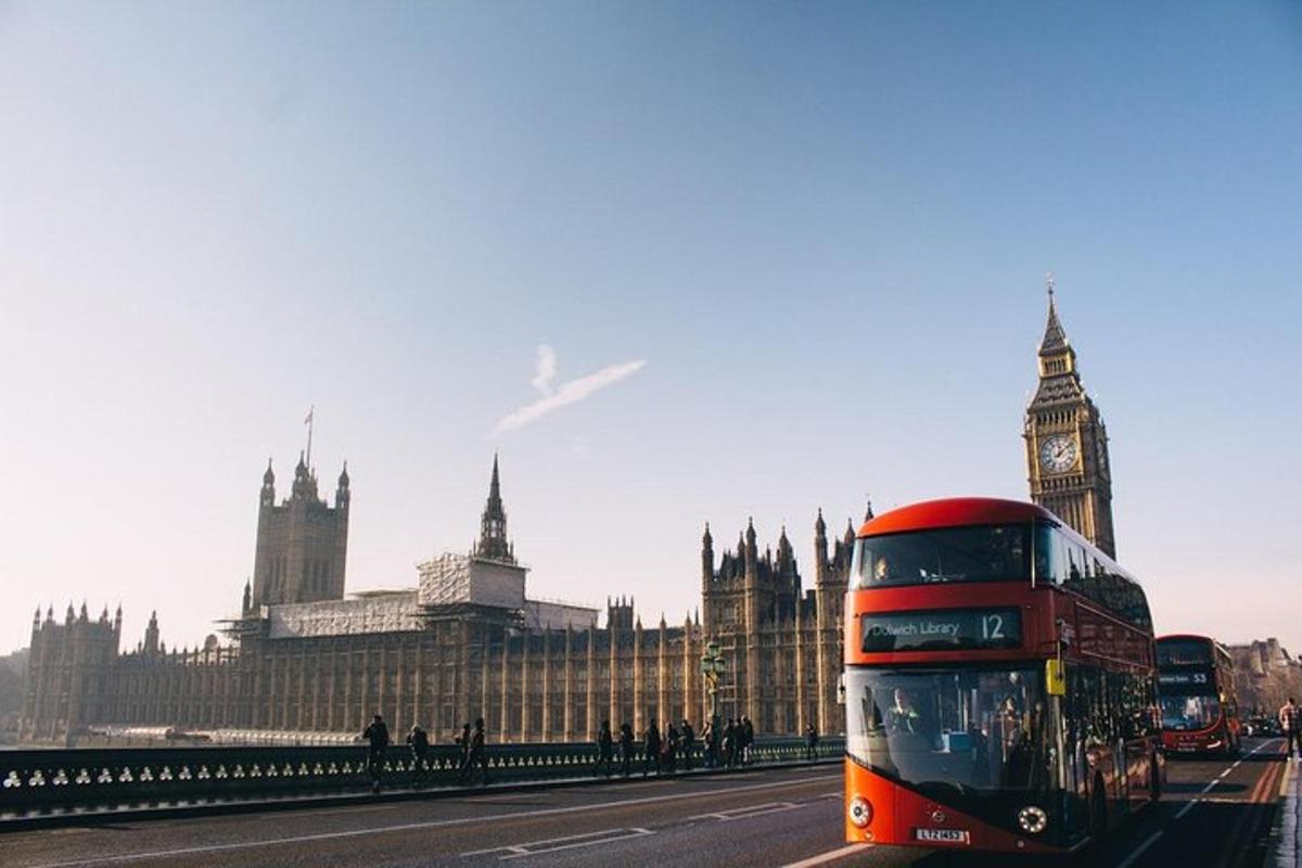 Červený dvoupatrový autobus projíždějící kolem hodinové věže Big Ben