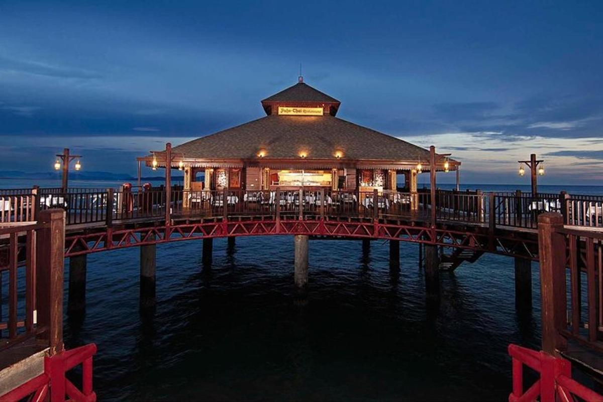 une jetée avec un restaurant sur l'eau la nuit