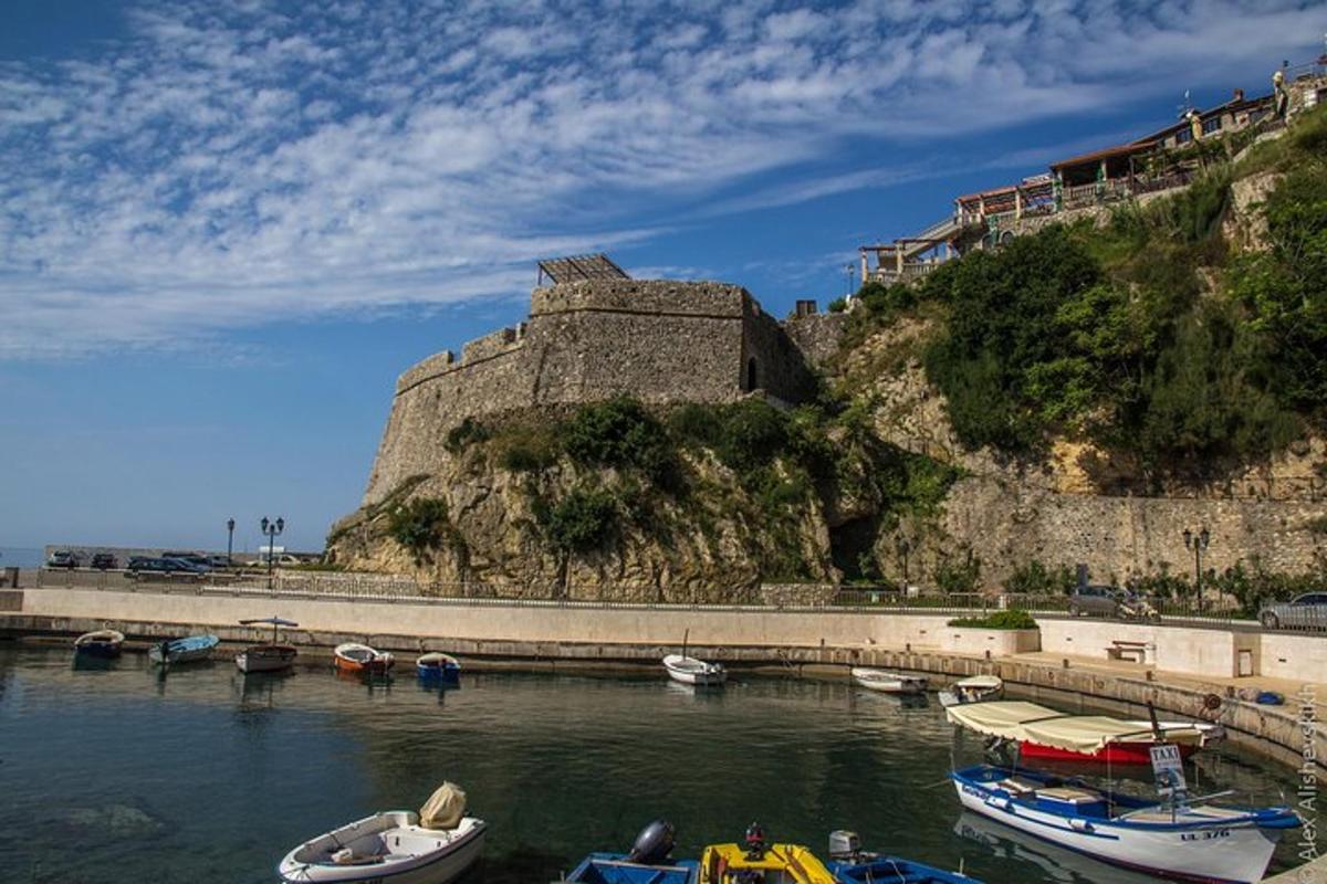 un gruppo di barche in acqua vicino a un castello