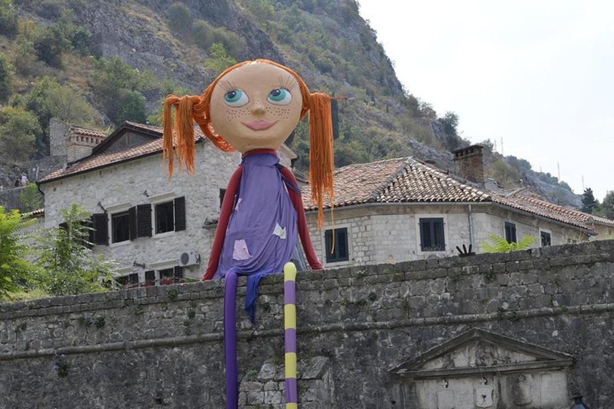 Una muñeca está sentada encima de una pared.
