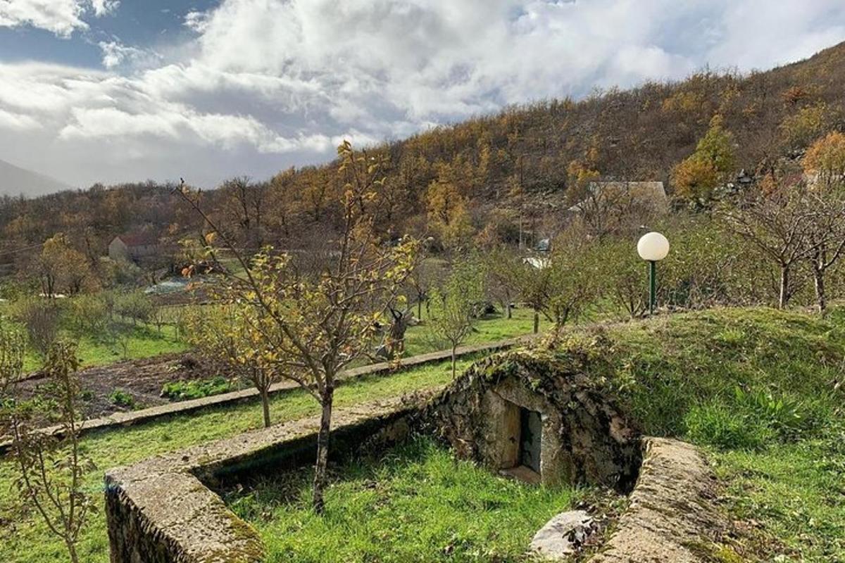 an old stone building in a field with a tree