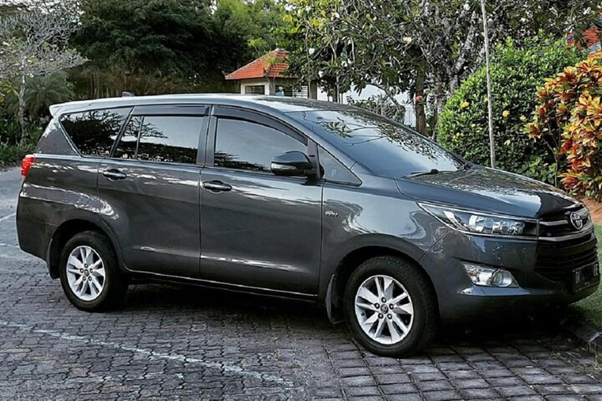 un minivan argentato parcheggiato su una strada di mattoni