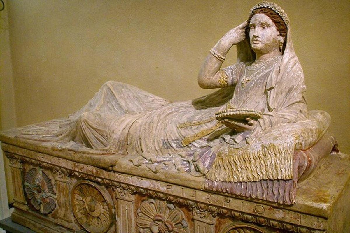 una statua di una donna seduta su un tavolo