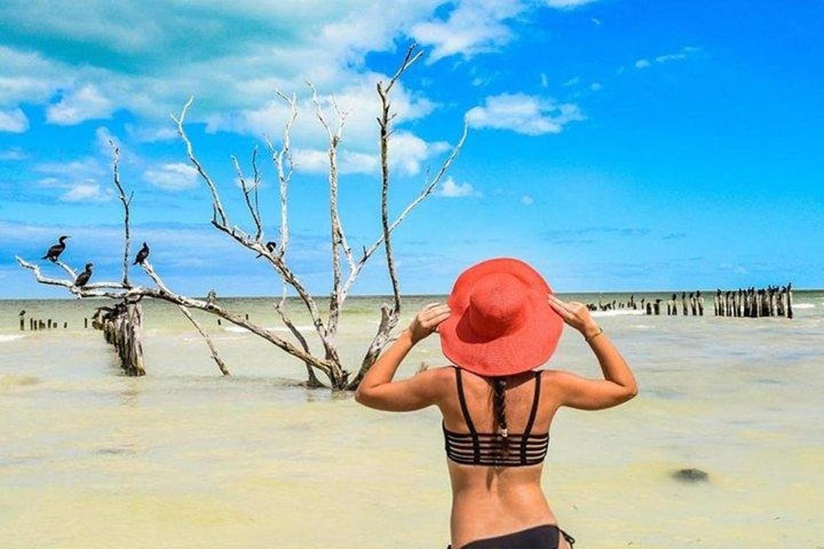 una donna con un cappello rosso sulla spiaggia