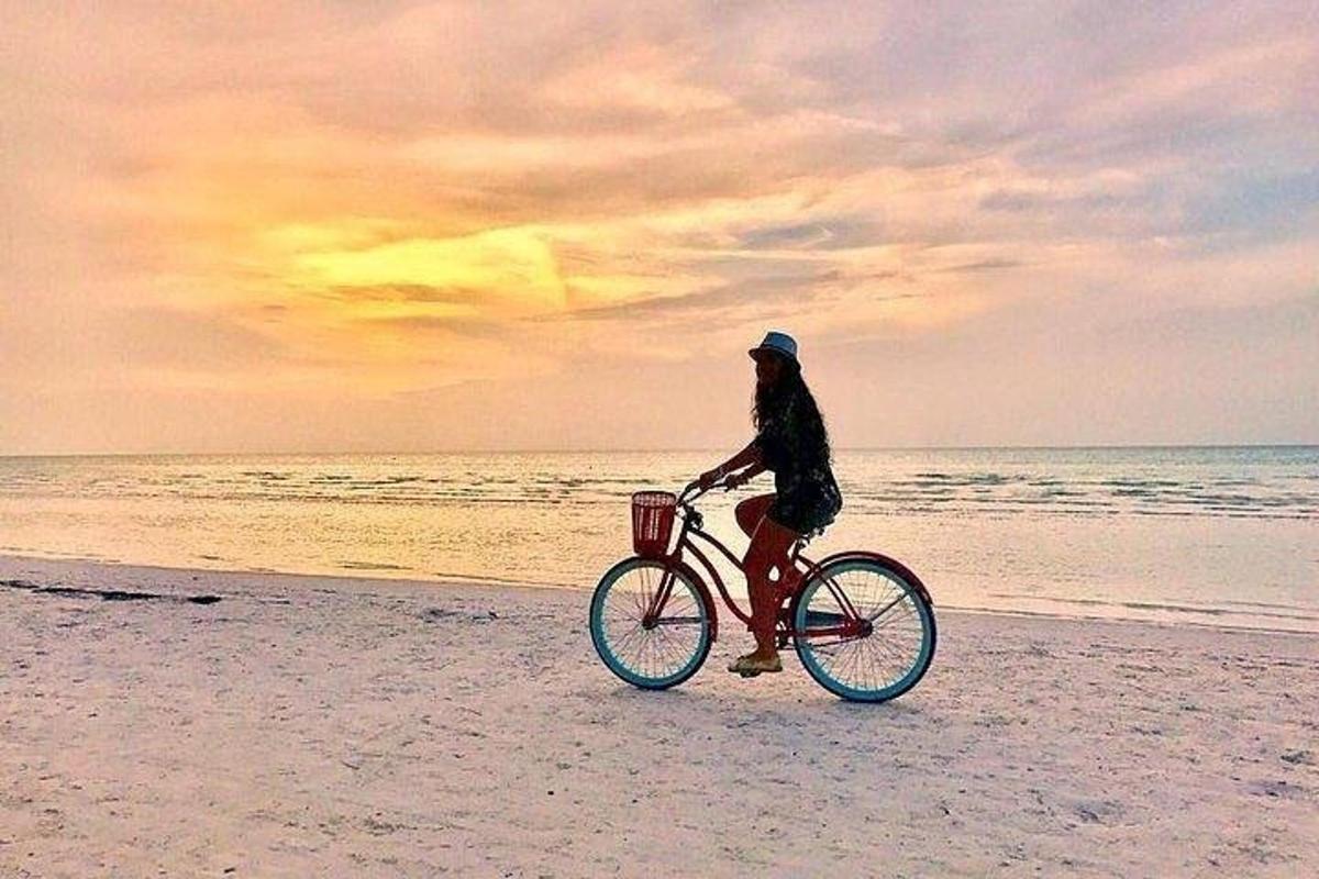una persona che va in bicicletta sulla spiaggia
