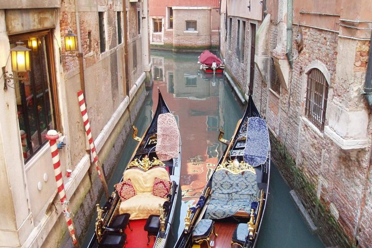 un gruppo di gondole in un canale tra due edifici