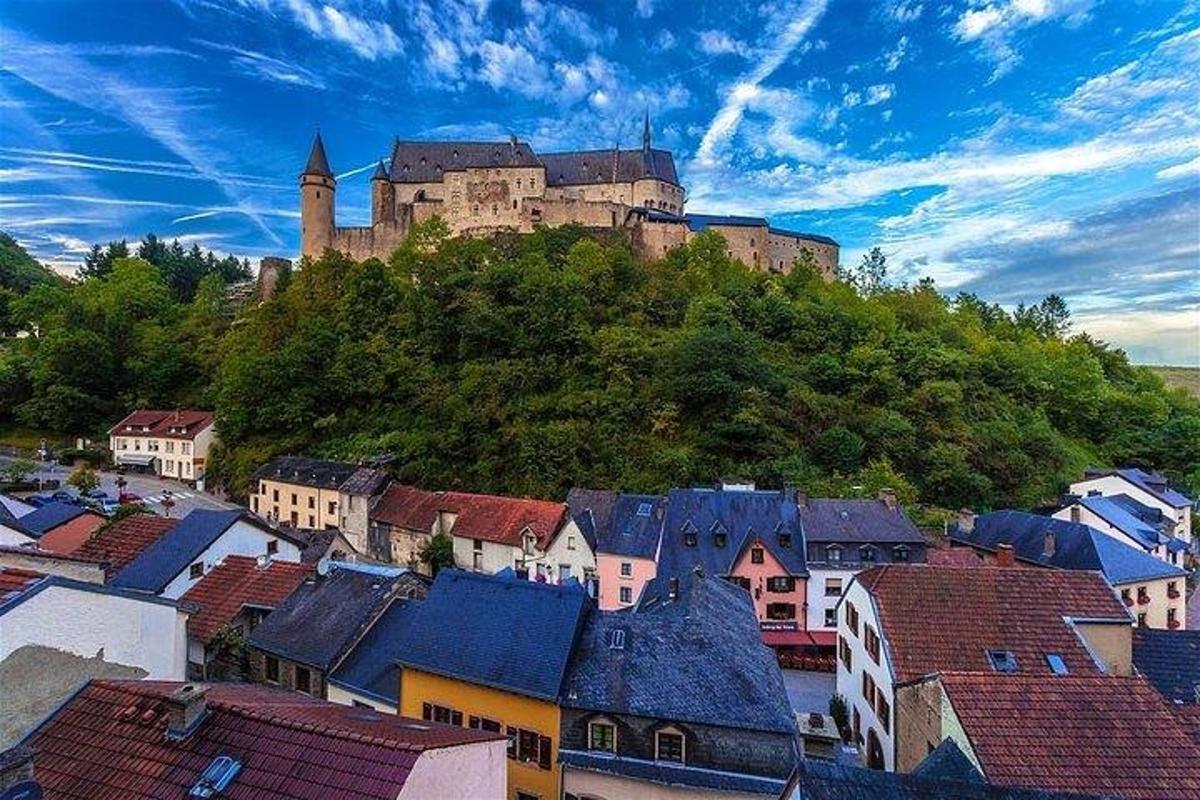 hrad stojící na vrcholu kopce s domy