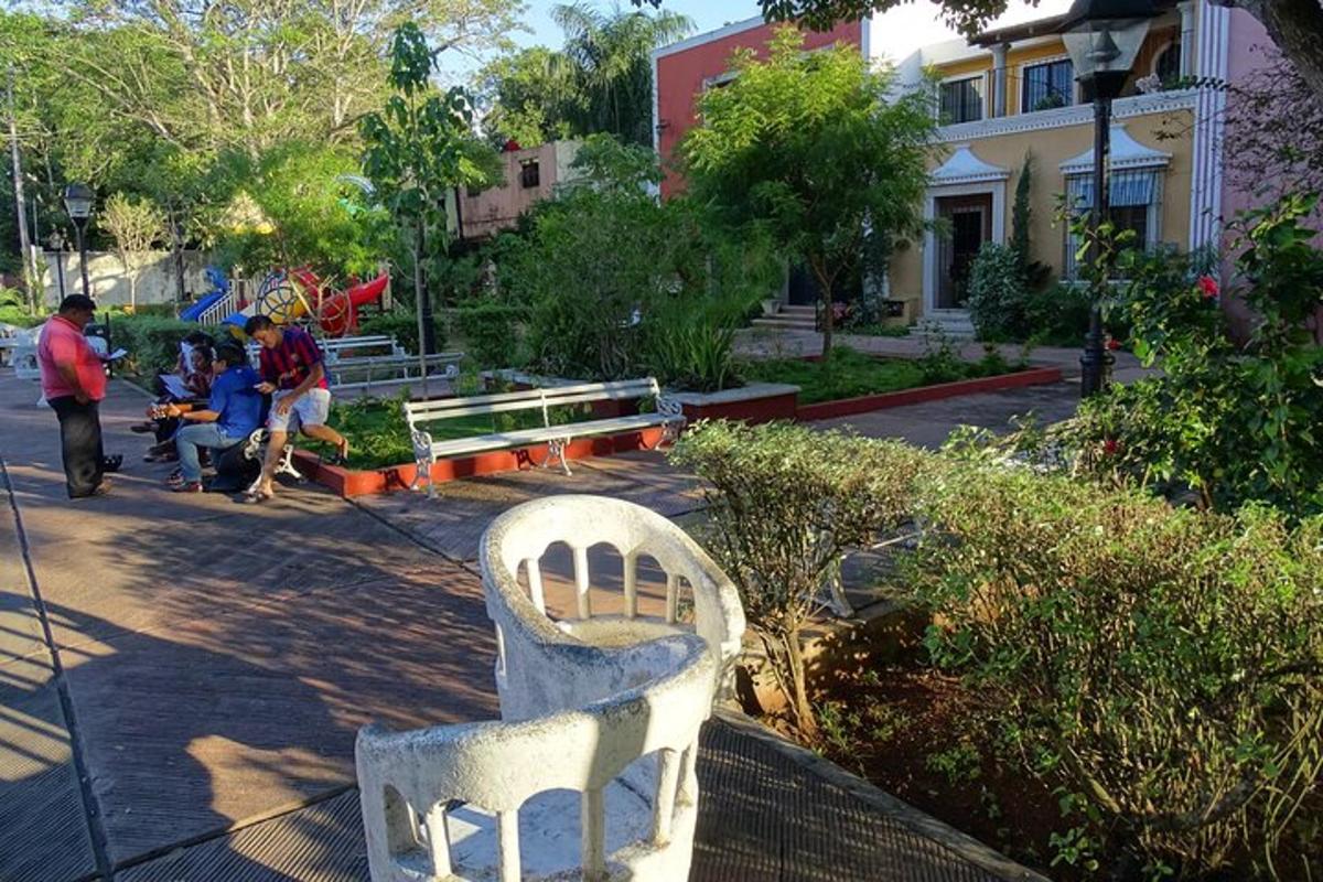 uma cadeira branca em um parque com pessoas sentadas em bancos