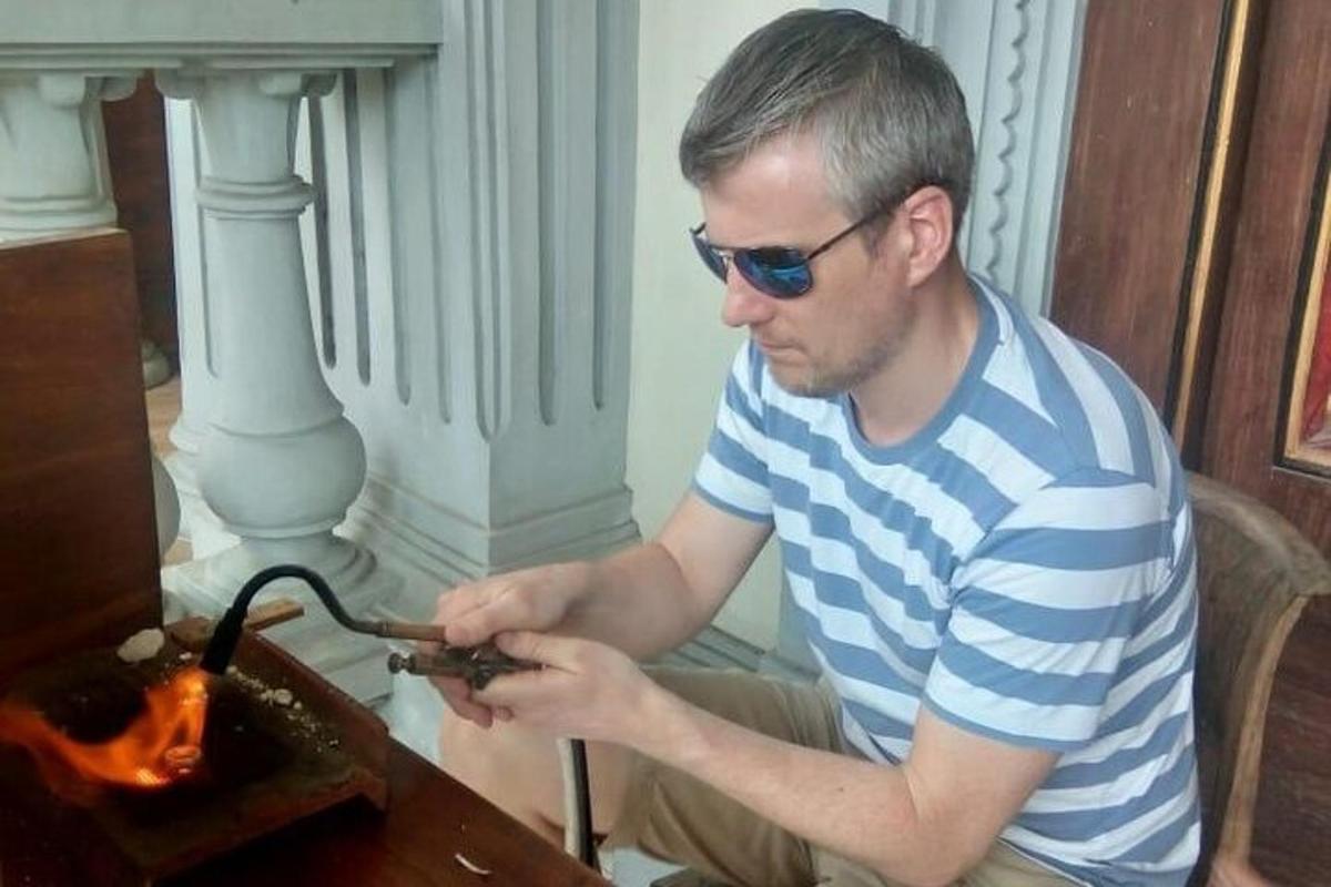 muž se slunečními brýlemi sedící u stolu s nějakým zařízením
