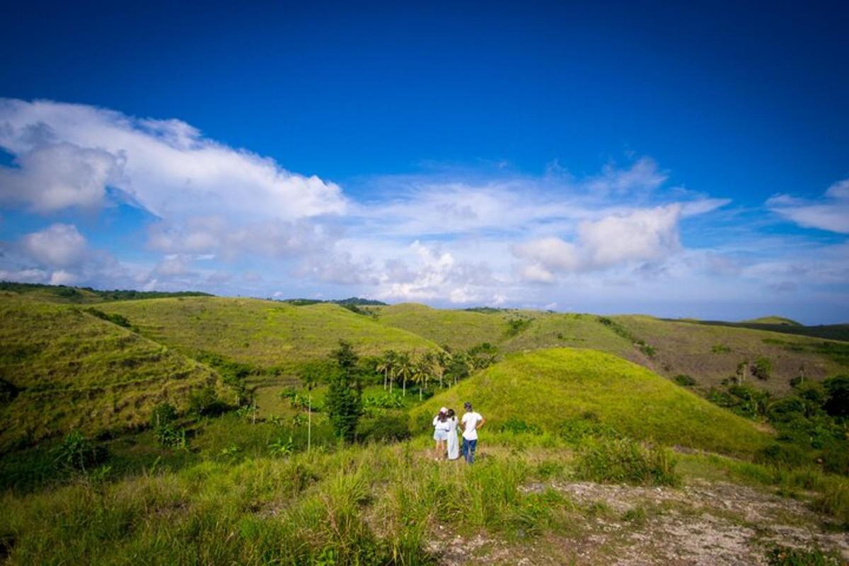 two people walking on a grassy hill