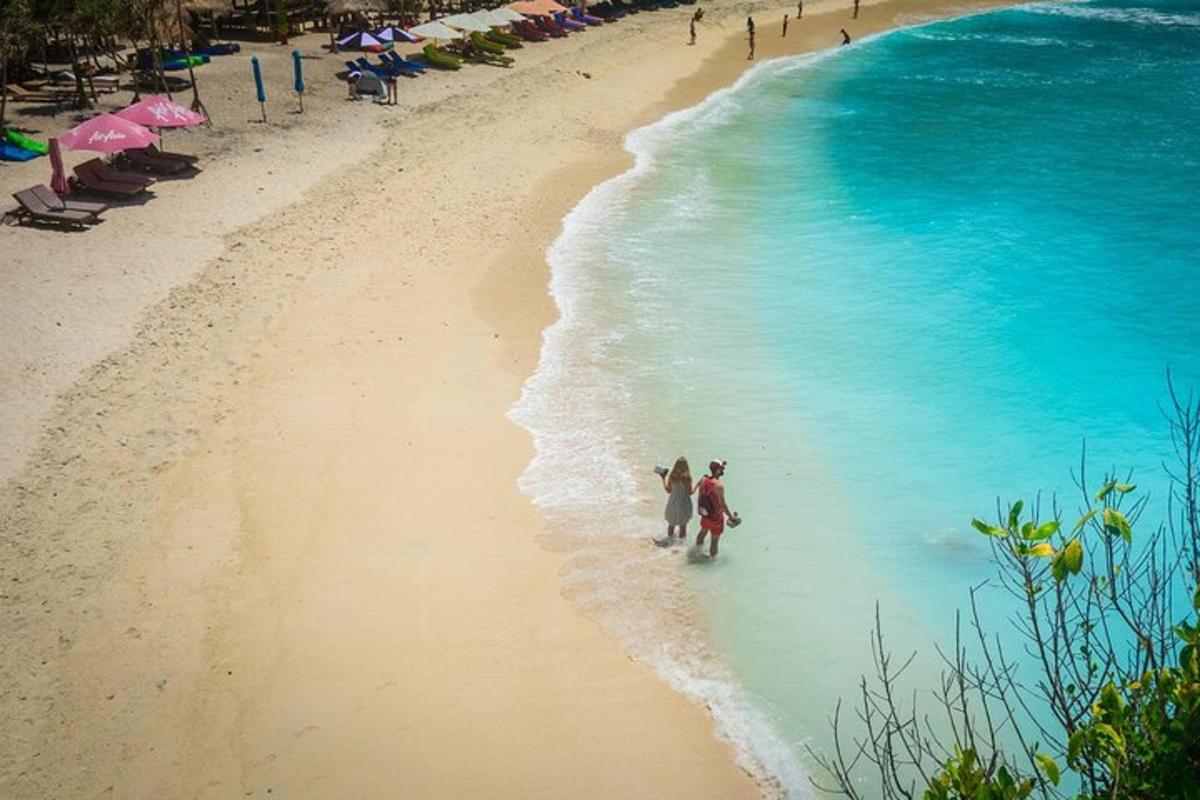 a group of people walking on the beach