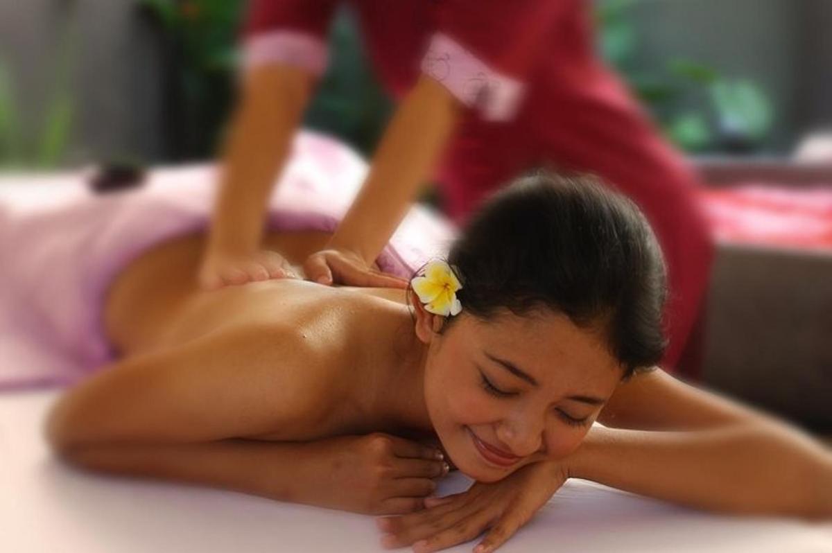 a young woman getting a back massage at a spa