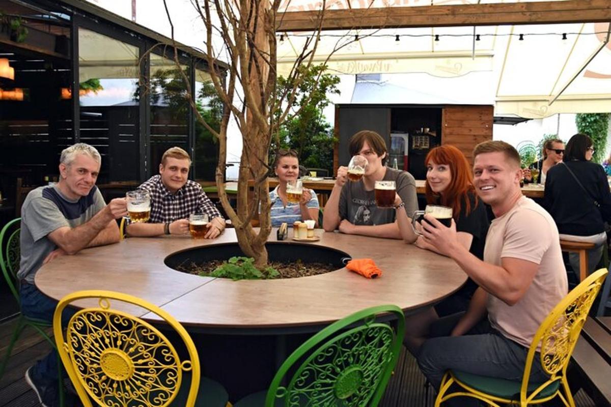 un grup de oameni așezați în jurul unei mese, bând vin