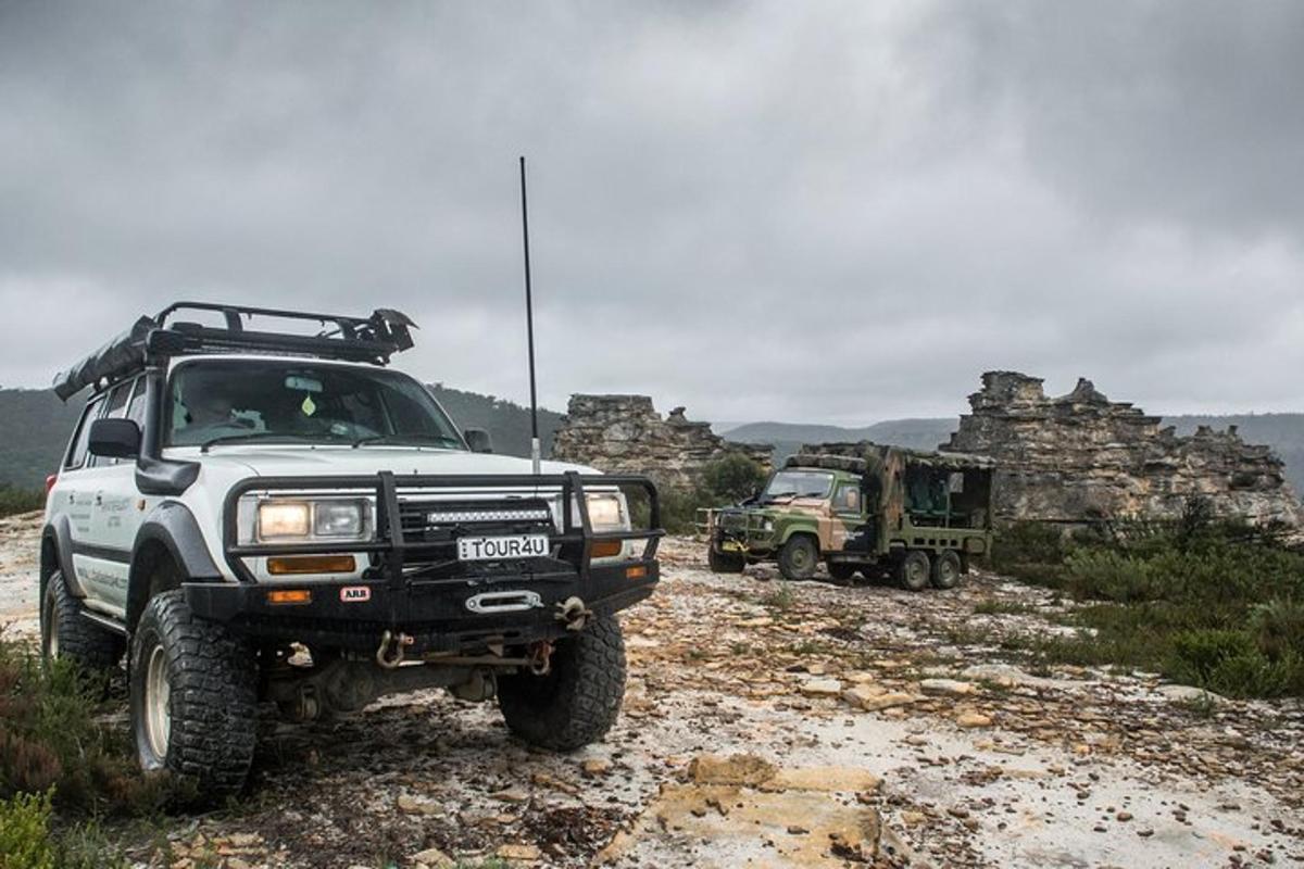 twee militaire vrachtwagens geparkeerd op een onverharde weg