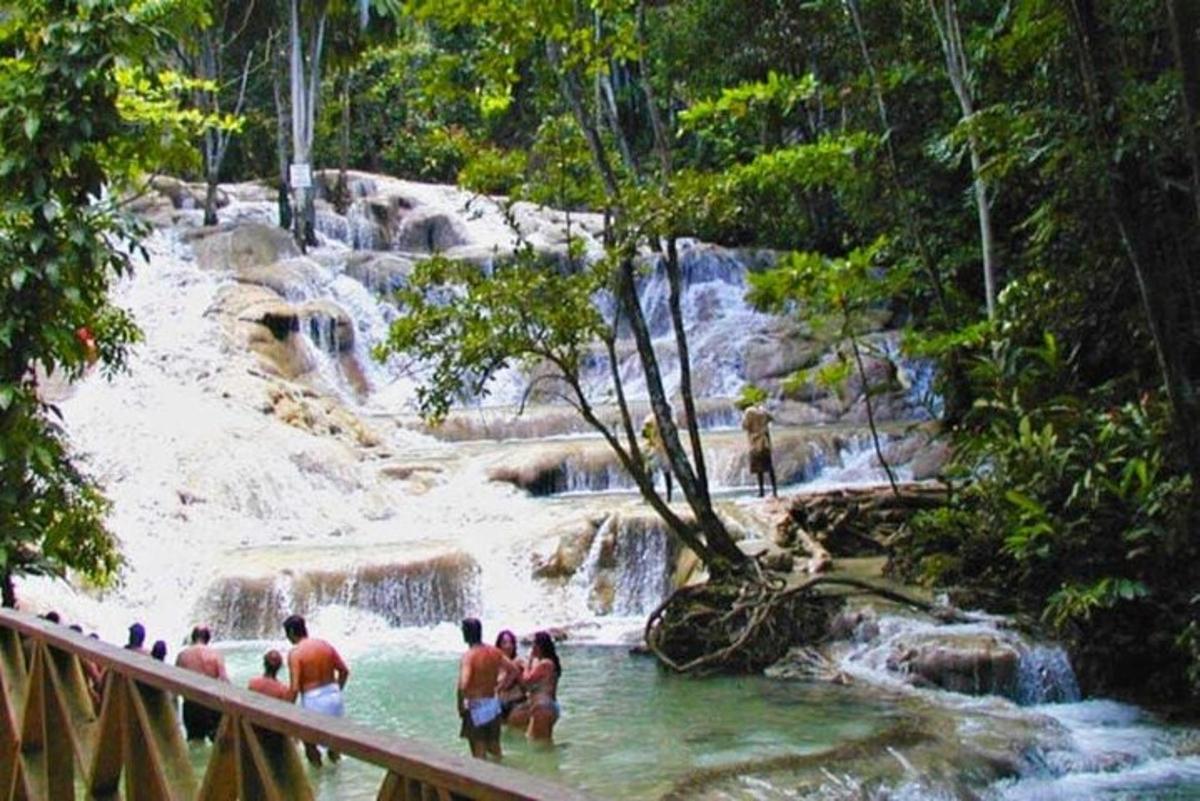 un grup de persones dempeus a l'aigua d'una cascada