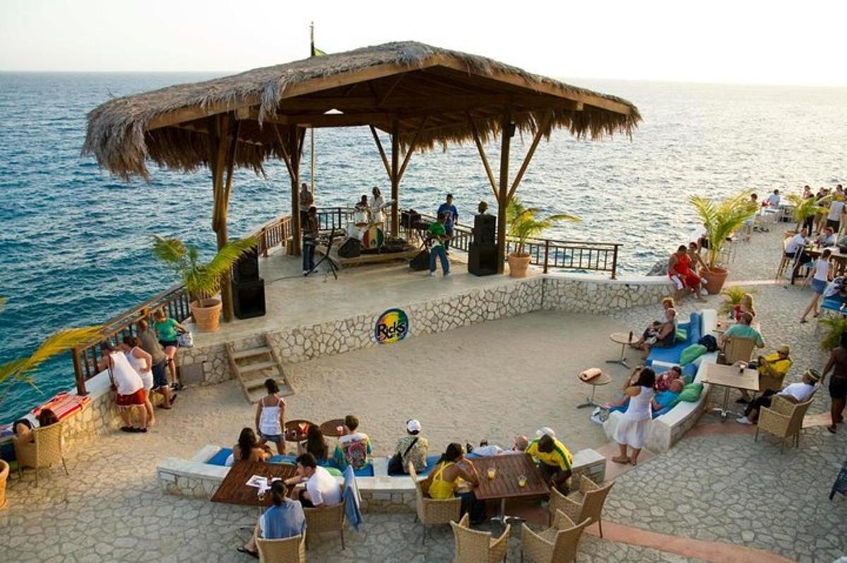 skupina lidí sedících v restauraci na pláži