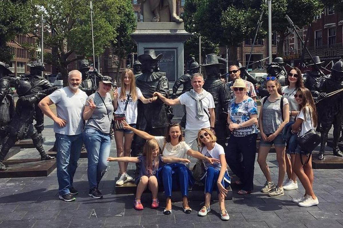skupina lidí pózujících před sochou