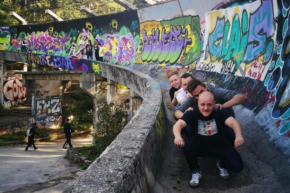 hópur fólks situr á vegg með veggjakroti