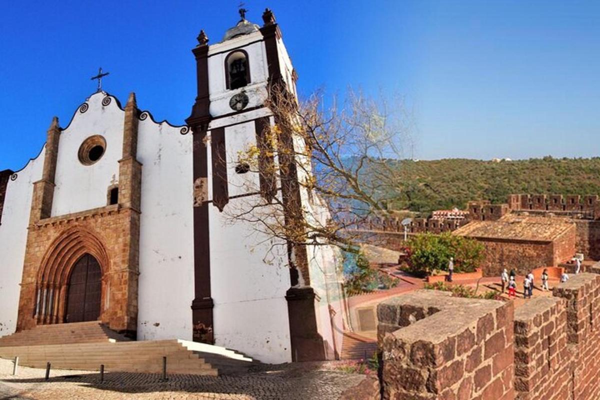 una chiesa con una torre dell'orologio accanto a un muro