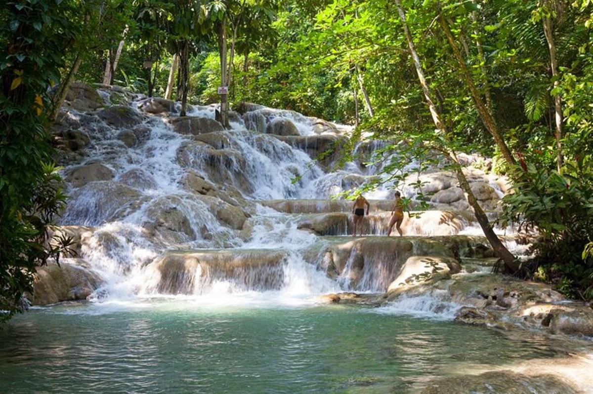 uma cachoeira com pessoas em pé na frente dela