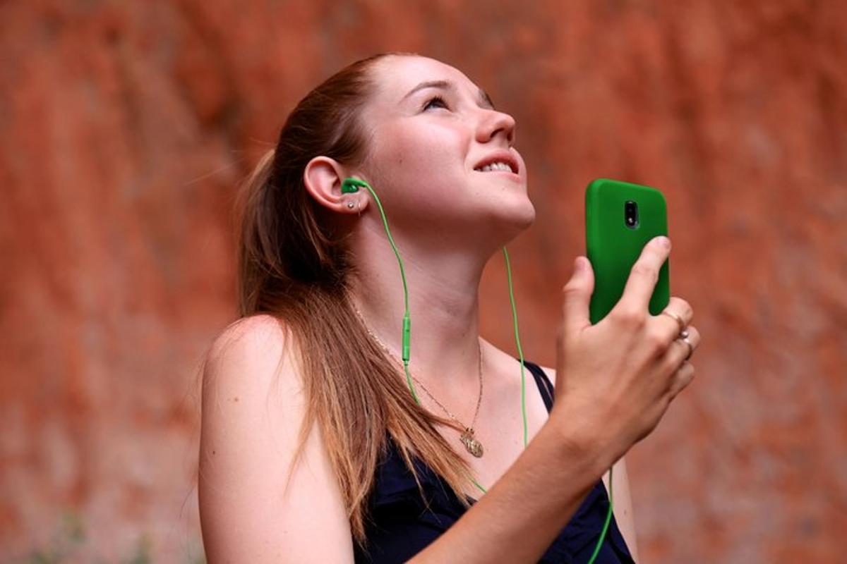 a young woman with headphones looking at her cell phone