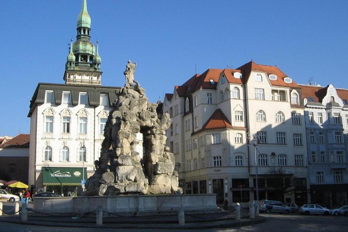 socha před velkou budovou s věží