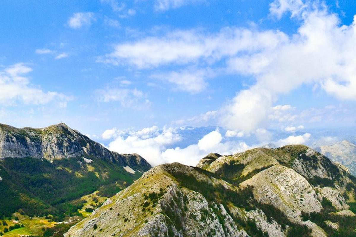 μια ομάδα βουνών με γαλάζιο ουρανό και σύννεφα