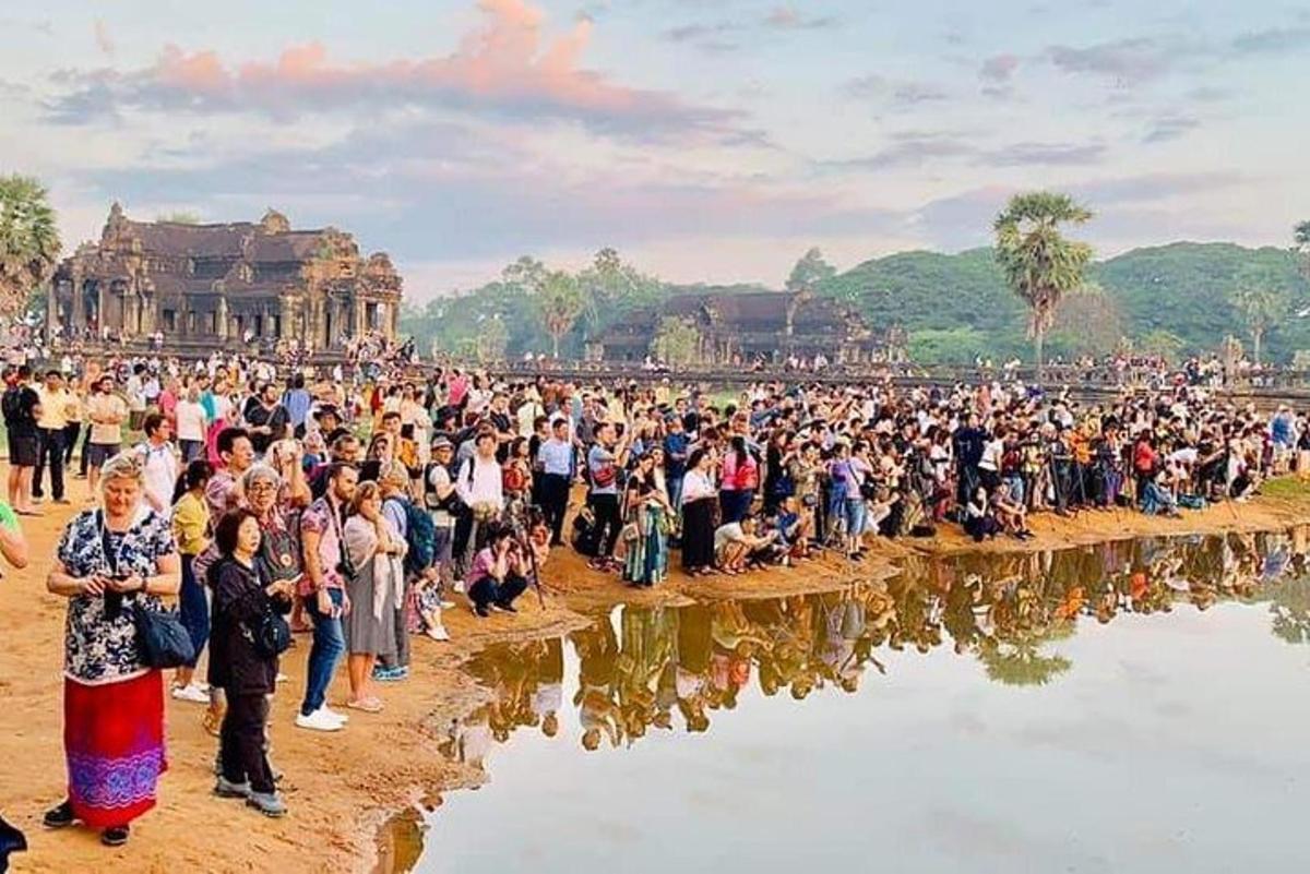 sekumpulan besar orang berdiri di sekeliling badan air