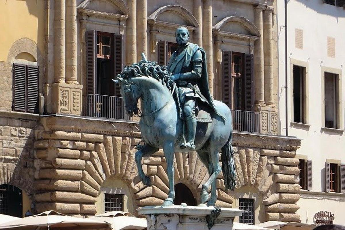 ένα άγαλμα ενός άνδρα που ιππεύει ένα άλογο μπροστά από ένα κτίριο