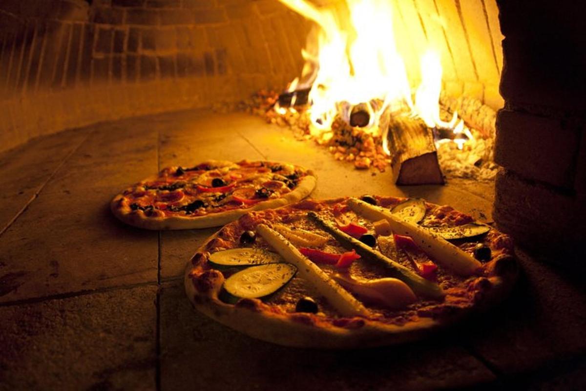 due pizze cotte in un forno a legna