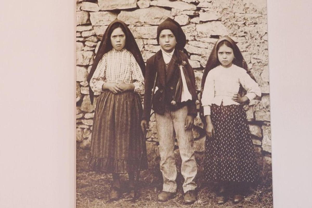 stará fotografia troch žien pred kamenným múrom