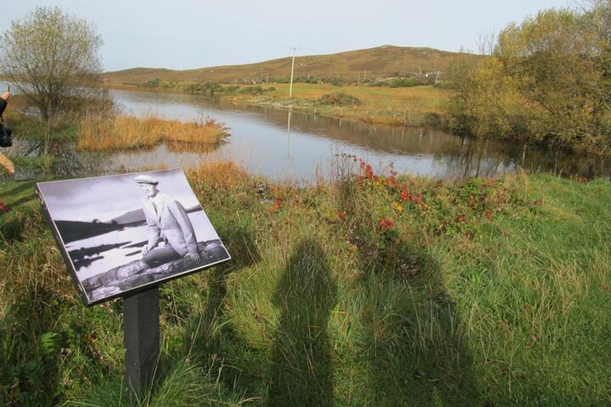 une photo en noir et blanc d'un homme sur un panneau à côté d'une rivière