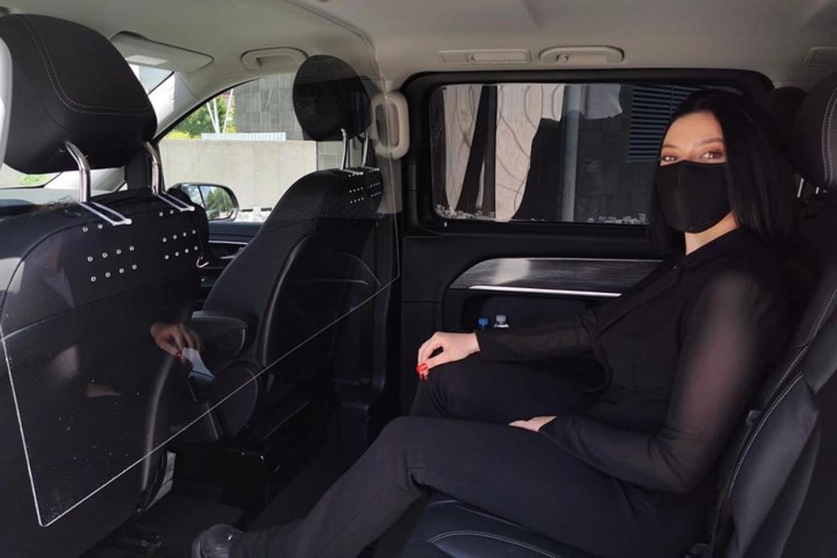 žena sedící v zadní části auta s plynovou maskou