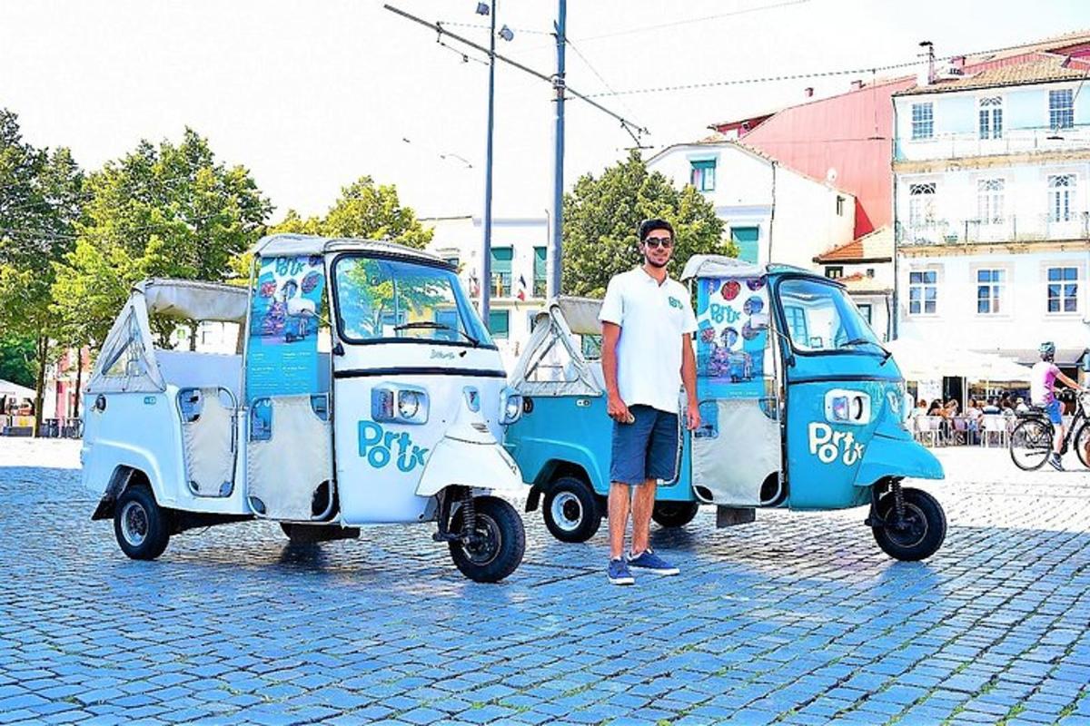 moški stoji poleg dveh majhnih avtomobilov