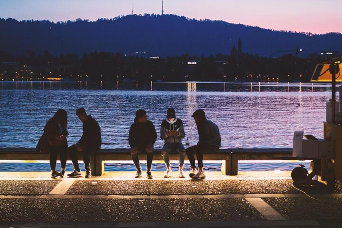 grupp inimesi istub pingil vee ääres